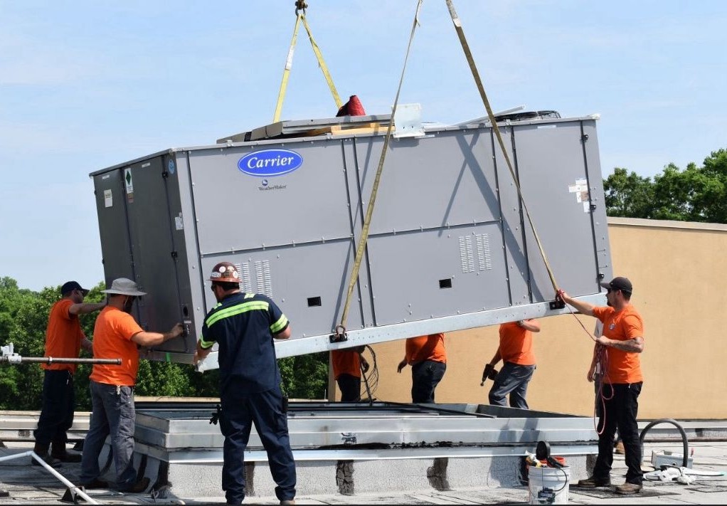 Guardian Air technicians craning a Carrier commercial rooftop HVAC unit into place in Laredo, TX