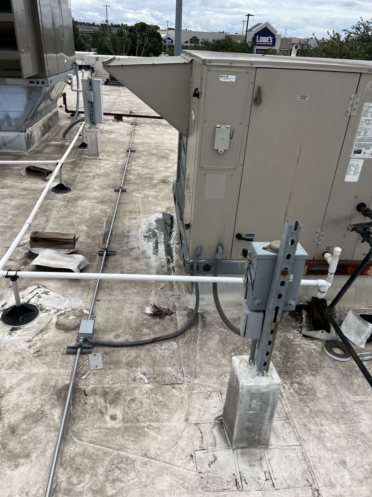 Guardian Air servicing a rooftop HVAC unit and disconnect at a South Texas retail plaza